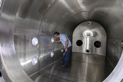 fabricator inside vacuum vessel.  Industrial Photography