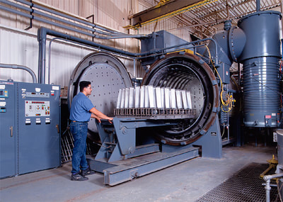 loading heat treating oven with recoated turbine blades, industrial photography